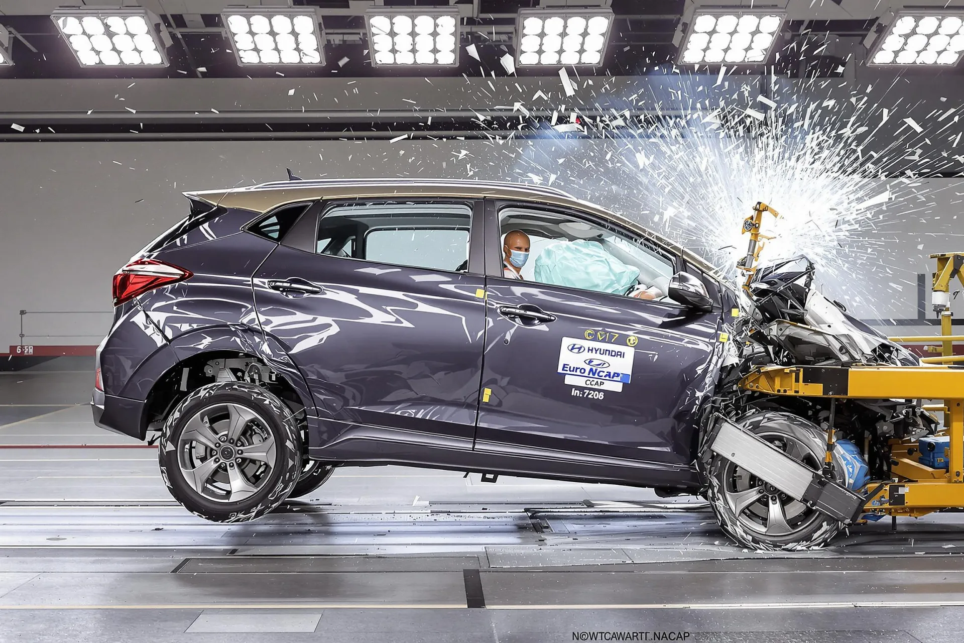 Une voiture Hyundai Inster subit un test de collision Euro NCAP avec des débris en suspension.