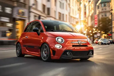 L'Abarth 600e en milieu urbain avec des lumières de ville floues en arrière-plan.