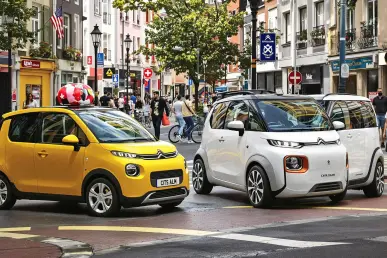 Un Citroën Ami et un Mobilize Duo sont garés côte à côte sur une rue animée.