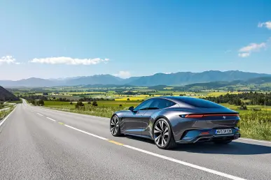 Une voiture diesel de 2025 est garée sur une route pittoresque entourée de verdure et de montagnes sous un ciel bleu.