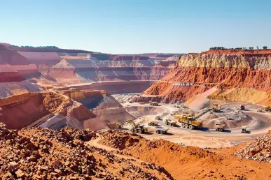 Une mine à ciel ouvert animée avec machines lourdes extrayant des terres rares.