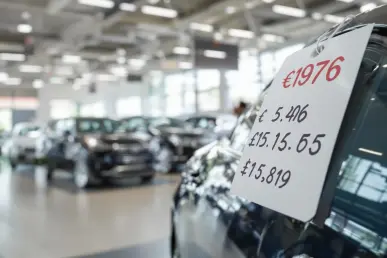 Une voiture de luxe dans un concessionnaire, avec un prix visible sur l'étiquette.