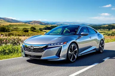 Une voiture hybride Honda moderne est garée sur une route pittoresque sous un ciel bleu clair.