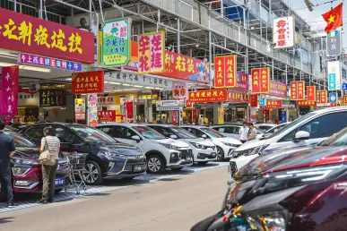 Des voitures alignées sur un marché automobile chinois avec des acheteurs actifs.