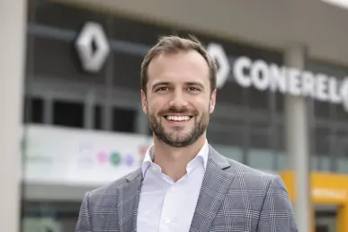 Maxime Picat pose devant un bâtiment moderne, symbolisant son potentiel rôle chez Renault.