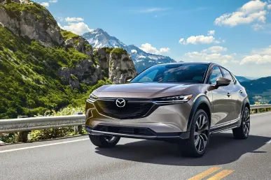 La Mazda EZ-60 SUV est photographiée sur une route de montagne panoramique.