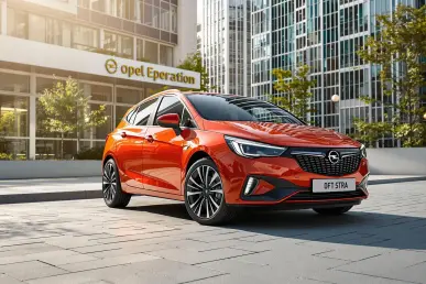 Une Opel Astra électrique stationnée dans une ville moderne, éclairée par la lumière naturelle.