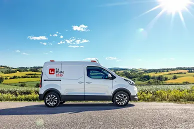 La Renault 4L La Poste 2025 électrique stationnée dans une campagne française ensoleillée.