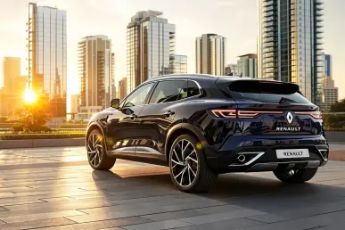 Un SUV Renault Rafale stationné en ville sous une lumière dorée, exposant ses lignes aérodynamiques.