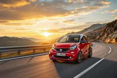 La Smart #5 Brabus roule sur une route de montagne au coucher du soleil.