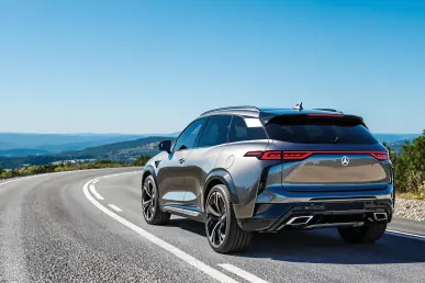 Un SUV électrique Smart #5 Brabus garé sur une route sinueuse entourée de verdure.