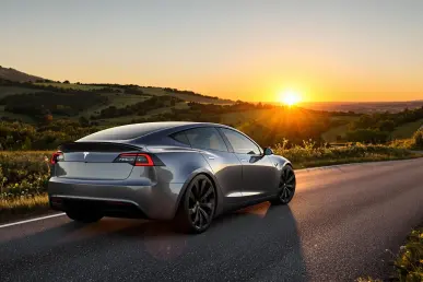 Une Tesla Model Y garée sur une route de campagne française au coucher du soleil.