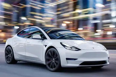 Une Tesla Model Y restylée stationnée en ville avec des immeubles en arrière-plan.