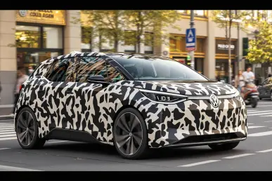 La Volkswagen ID.2 partiellement camouflée, stationnée dans un cadre urbain animé.