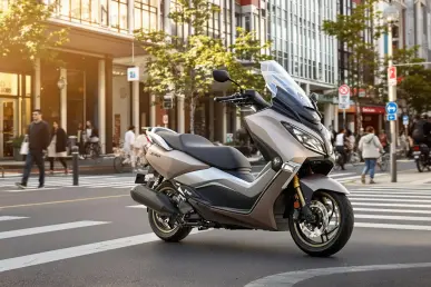 Le scooter X-Max 125 Tech Max stationné sur une rue animée de la ville avec des bâtiments modernes en arrière-plan.